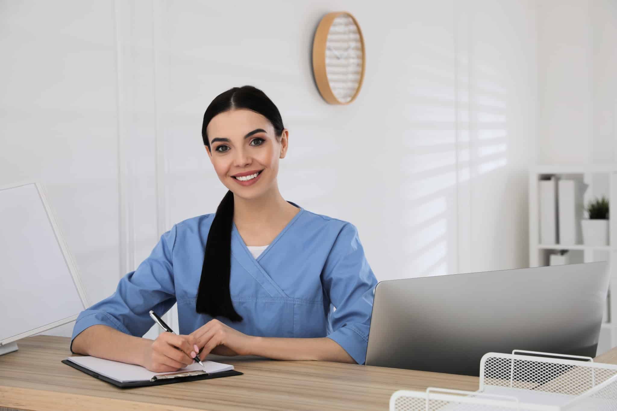 Young healthcare worker writing on a clipboard