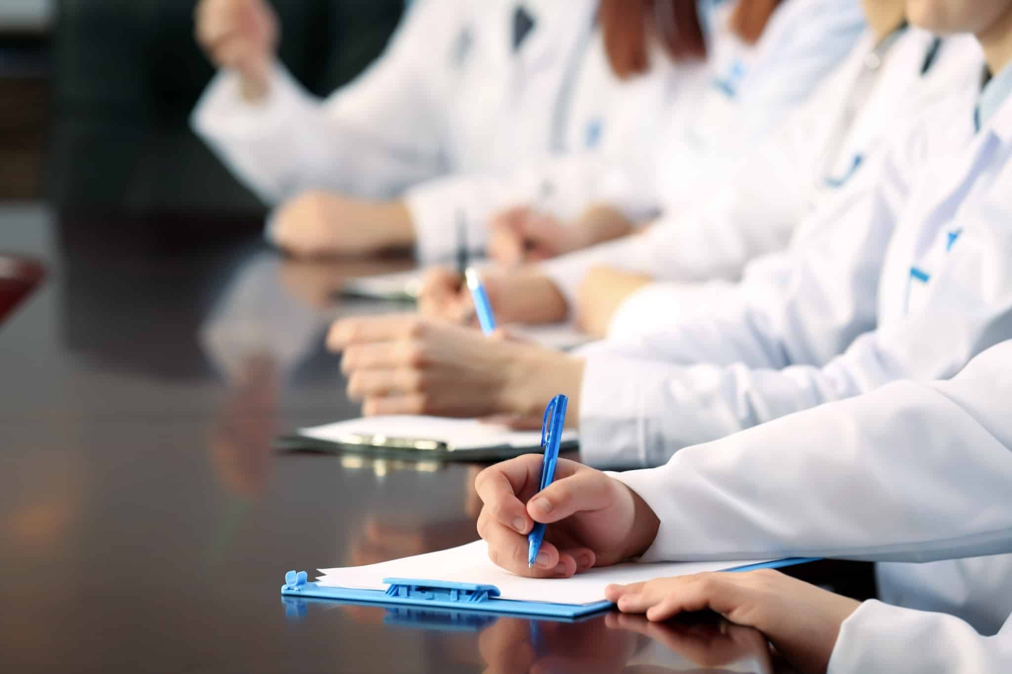 Close up of medical students writing on clipboards